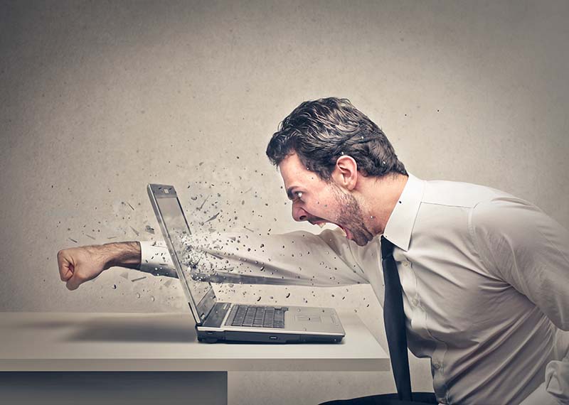 man punching screen of laptop in anger of billing system