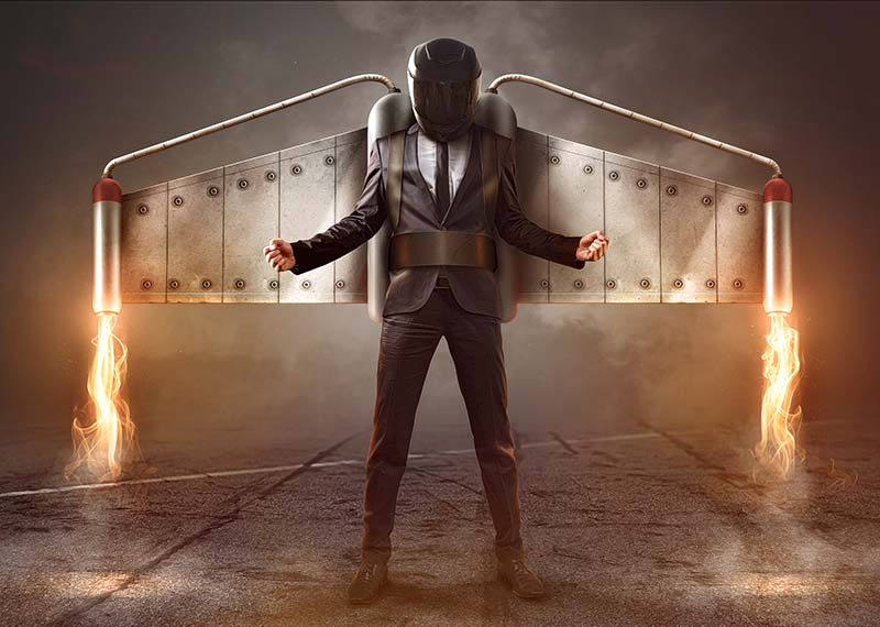 Business man with helmet and wings connected to jetpack