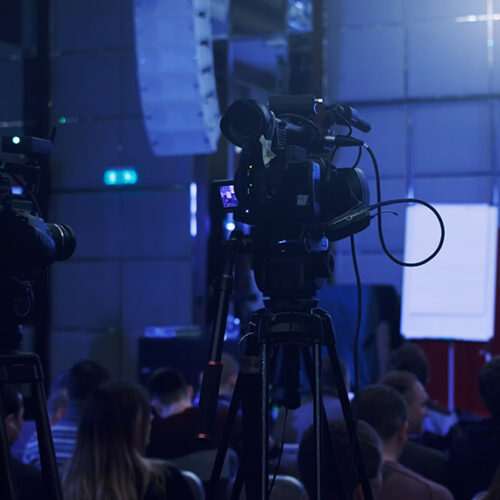 video cameras in front of a conference stage