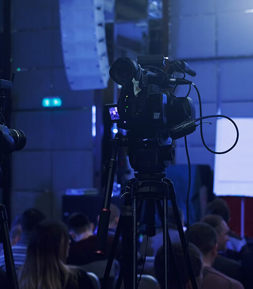 video cameras in front of a conference stage
