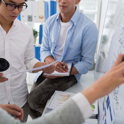 High Growth Team Diagraming Workflow on White Board