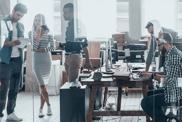 Team of business people collaborating in open office floorpan environment