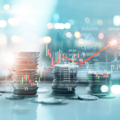 stack of coins with financial charts in the foreground