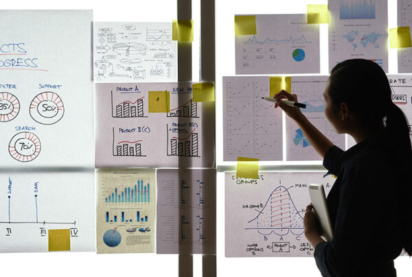 business woman analyzing charts taped to a clear glass window