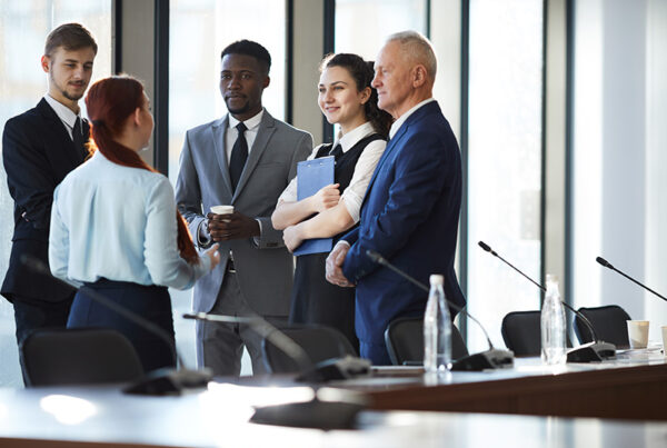 business people dressed in suits huddling outside conference room