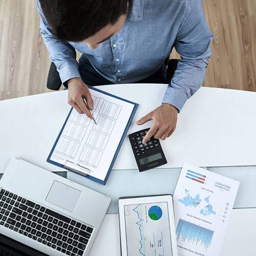 SaaS finance professional reviewing charts of gross revenue retention on tablet at desk