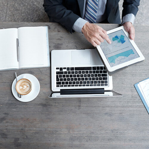 saas finance leader reviewing gross revenue retention charts on a tablet with cup of coffee