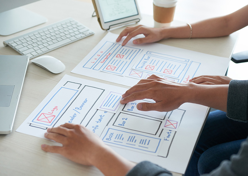 two designers reviewing wireframes of a saas website