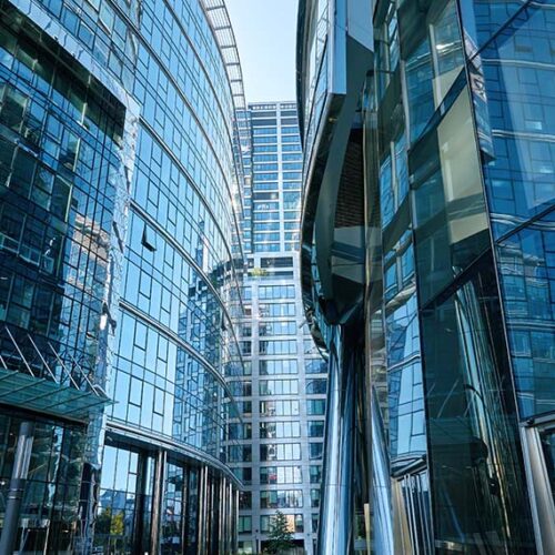 view three office buildings coming together, each with blue shaded glass