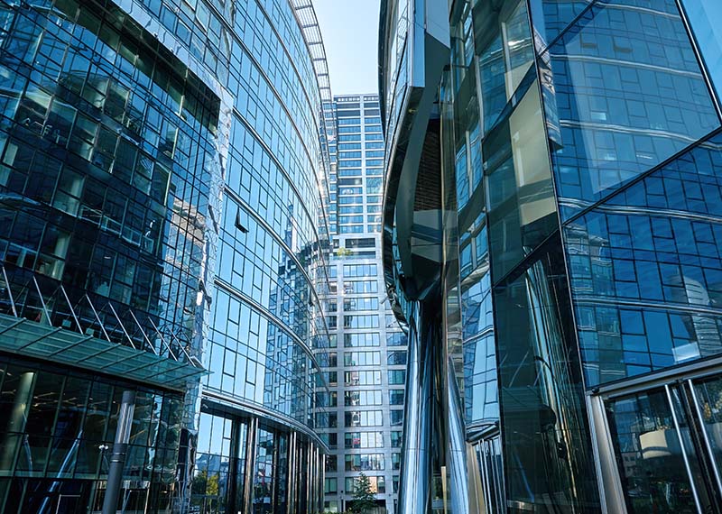 view three office buildings coming together, each with blue shaded glass