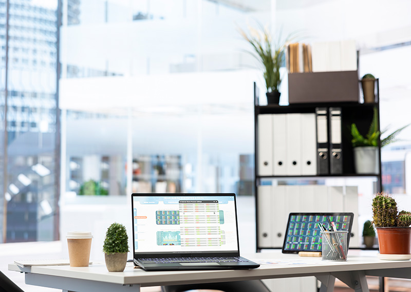 modern office with laptop on desk and buildings in the background