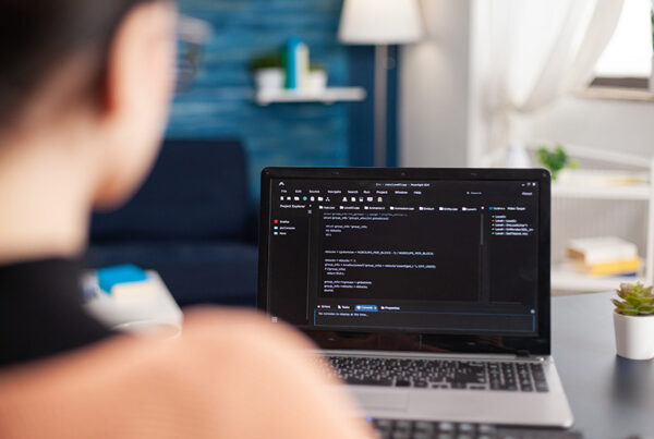 business woman at desk with laptop in the foreground evaluating free trial SaaS