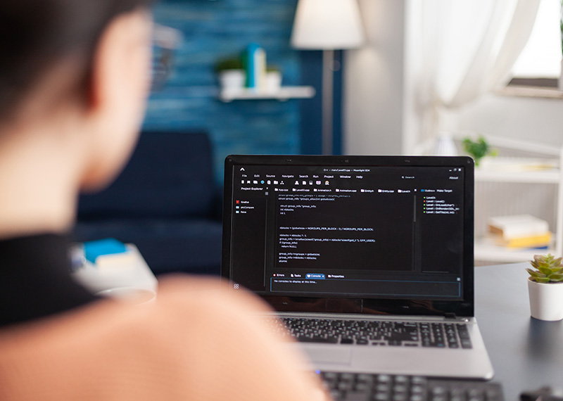 business woman at desk with laptop in the foreground evaluating free trial SaaS