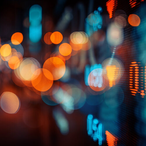 stock ticker with blue and orange lights in background
