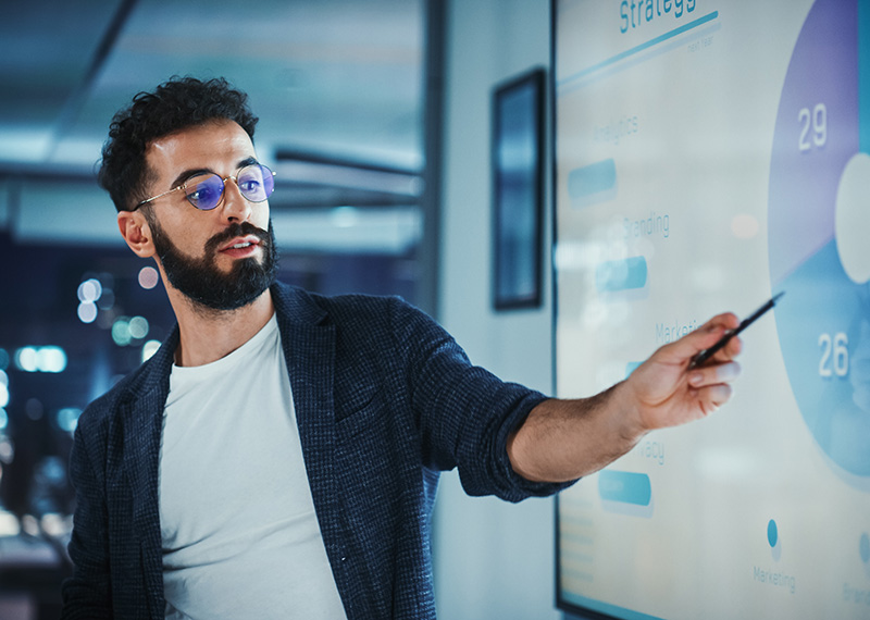 Financial controller showing chart with remaining performance obligations on large TV mounted on wall