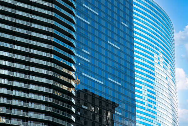 three office buildings with glass exteriors and reflections