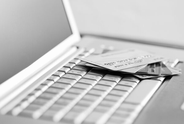 silver credit cards on top of a silver laptop