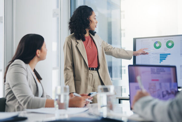 Go-to-market team discussing quote-to-cash metrics with Hubspot CRM screen in background