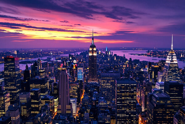 new york city skyline at sunset with shades of purple and orange on horizon