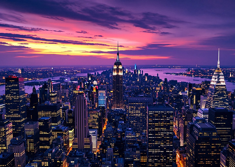 new york city skyline at sunset with shades of purple and orange on horizon