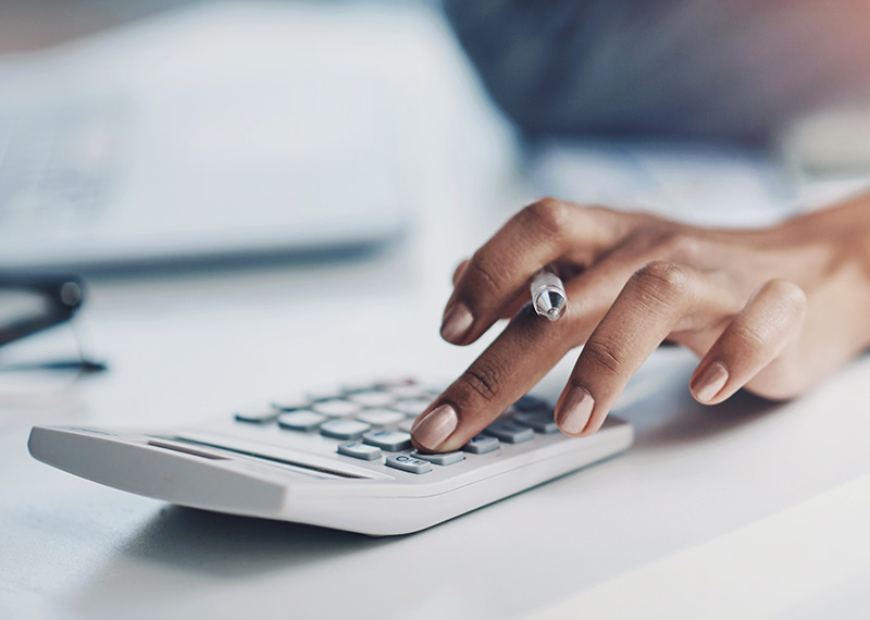 business woman's hand on calculator on white desk