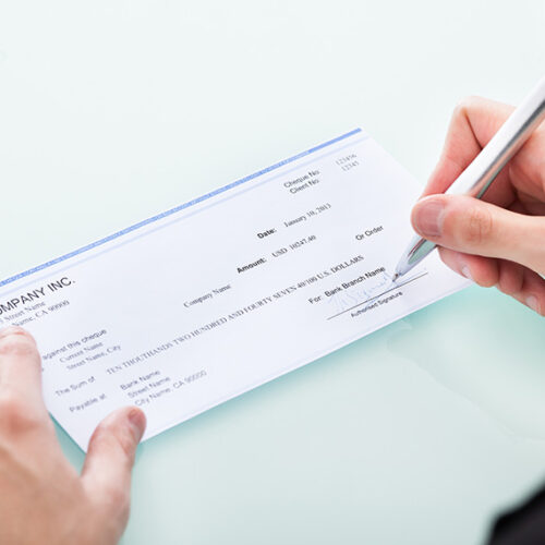 business man signing a paper check payment