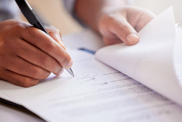 business man with pen in hand signing a recurring revenue contract