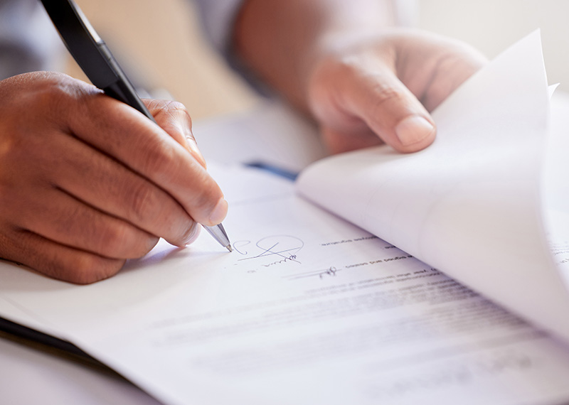 business man with pen in hand signing a recurring revenue contract