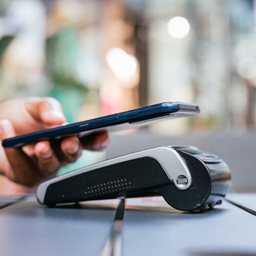 customer paying at business point of sale with Apple Pay on mobile phone
