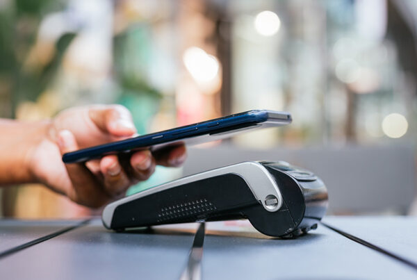 customer paying at business point of sale with Apple Pay on mobile phone