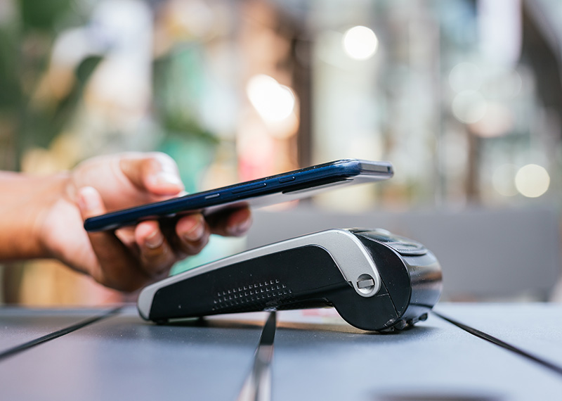 customer paying at business point of sale with Apple Pay on mobile phone