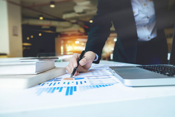 business man reviewing canadian PAD transactions on charts on desk