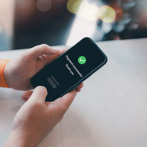 business woman using mobile phone to pay bill with Google Pay