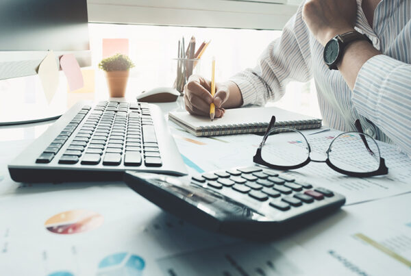 business customer reviewing overage fees on invoice at desk with calculator