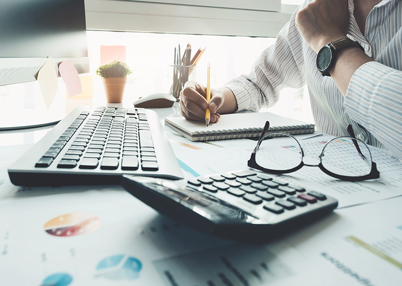business customer reviewing overage fees on invoice at desk with calculator
