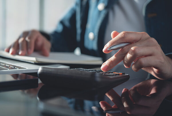 accountant using calculator to write off bad debt