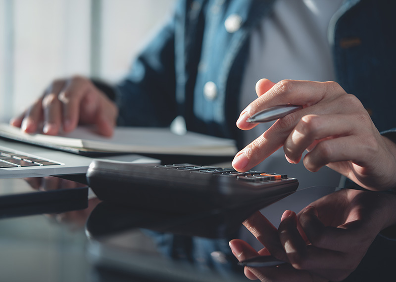 accountant using calculator to write off bad debt