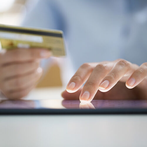 man typing credit card number into tablet