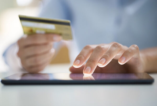 man typing credit card number into tablet
