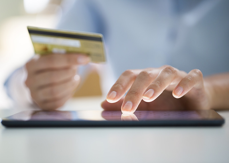 man typing credit card number into tablet