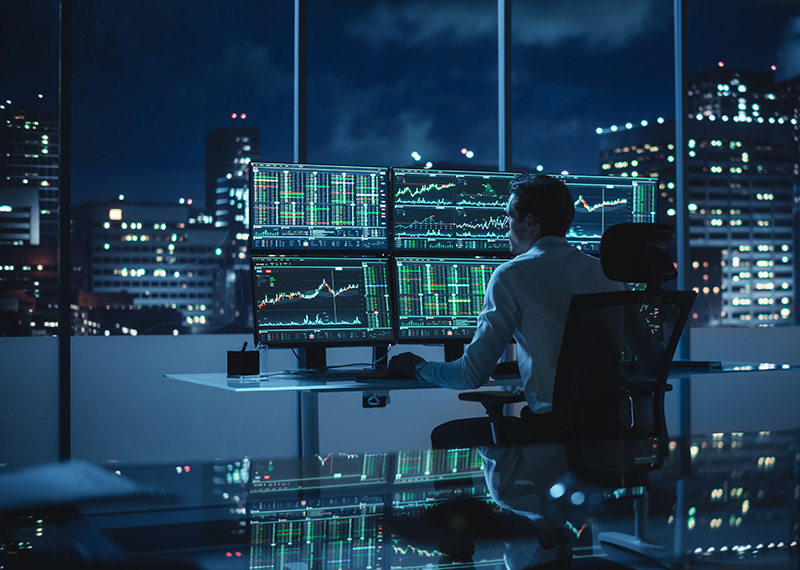 wall street trader making stablecoin payments in office at night with cityscape in background