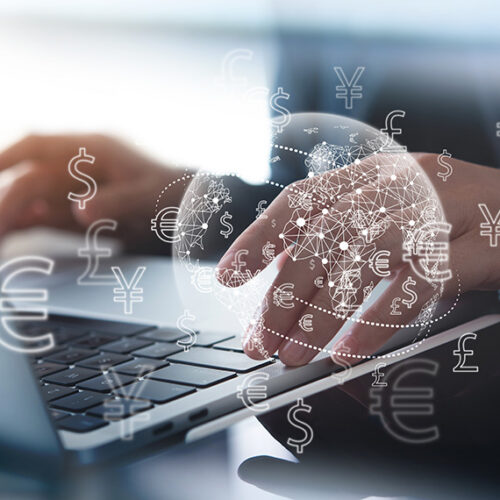 business man typing foreign currency transactions into laptop
