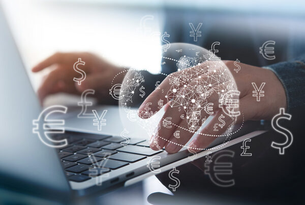 business man typing foreign currency transactions into laptop