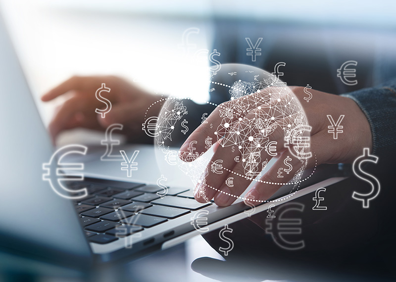 business man typing foreign currency transactions into laptop