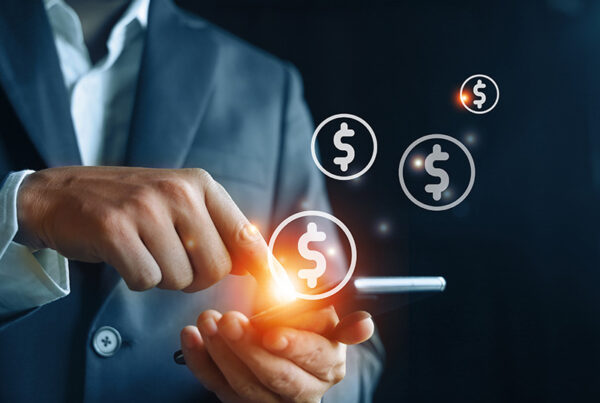 Business man holding smartphone with dollars signs above it