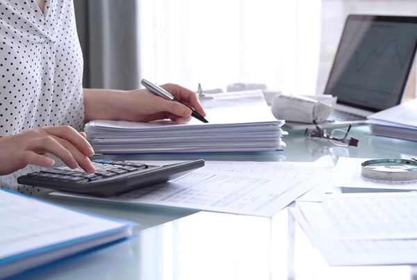 auditor reviewing revenue accounting journal entries on desk in office setting