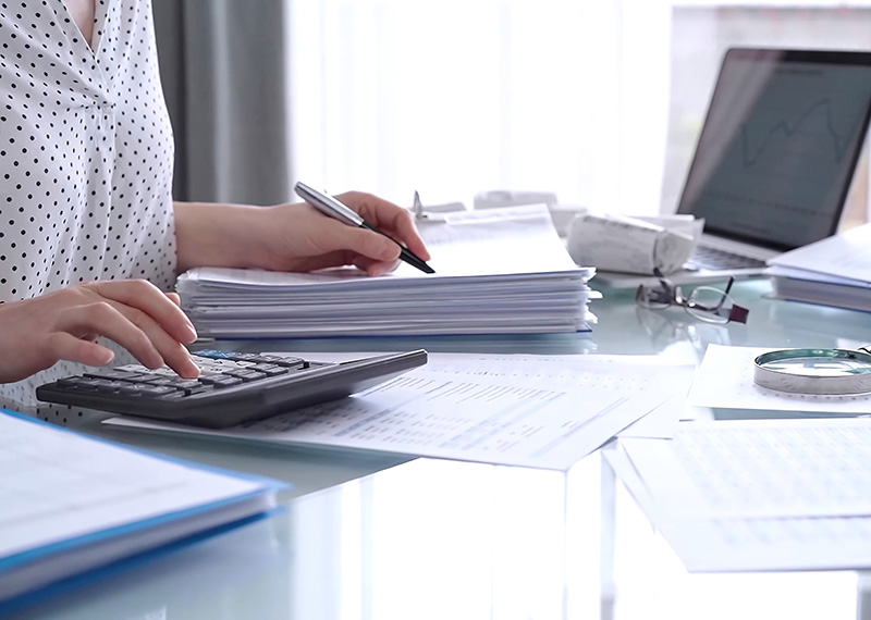 auditor reviewing revenue accounting journal entries on desk in office setting